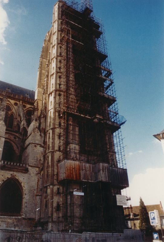 Photographie présentant la face nord de la tour nord de la cathédrale échafaudée pour des travaux de maçonnerie, vers 1990. AD du Cher, 36 Fi